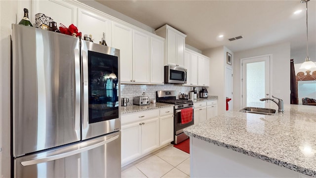 16250 Firedragon Dr, Winter Garden, FL 34787 - kitchen with stainless steel appliances, backsplash, white cabinetry, light stone countertops, and recessed lighting