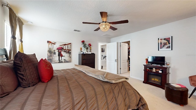 16250 Firedragon Dr, Winter Garden, FL 34787 - bedroom featuring carpet, a spacious closet, ceiling fan, and a glass covered fireplace