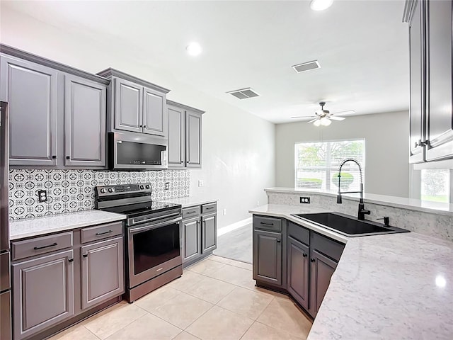 11127 Irish Moss Ave, Riverview, FL 33569 - kitchen featuring stainless steel appliances, ceiling fan, backsplash, light tile patterned floors, and gray cabinets