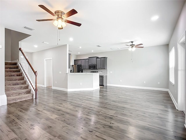 11127 Irish Moss Ave, Riverview, FL 33569 - unfurnished living room featuring a ceiling fan, recessed lighting, stairs, and dark wood-style floors