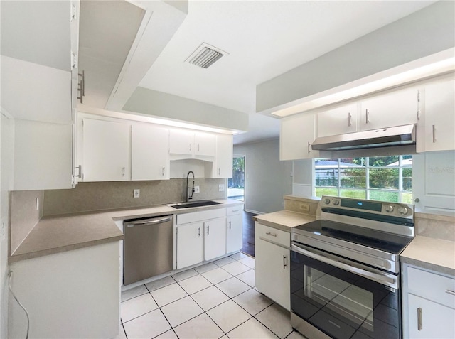 1215 Merlyn St, Lakeland, FL 33813 - kitchen featuring appliances with stainless steel finishes, under cabinet range hood, backsplash, and white cabinetry