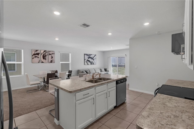 1296 Berry Ln, Davenport, FL 33837 - kitchen with stainless steel dishwasher, open floor plan, white cabinetry, light tile patterned floors, and an island with sink