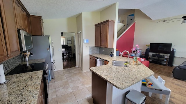 1632 Slash Pine Pl, Oviedo, FL 32765 - kitchen featuring appliances with stainless steel finishes, a peninsula, lofted ceiling, open floor plan, and tasteful backsplash