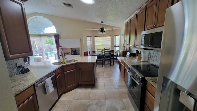 1632 Slash Pine Pl, Oviedo, FL 32765 - kitchen with stainless steel appliances, lofted ceiling, a ceiling fan, backsplash, and healthy amount of natural light