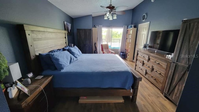 1632 Slash Pine Pl, Oviedo, FL 32765 - bedroom featuring light wood-type flooring, vaulted ceiling, a textured ceiling, and a ceiling fan
