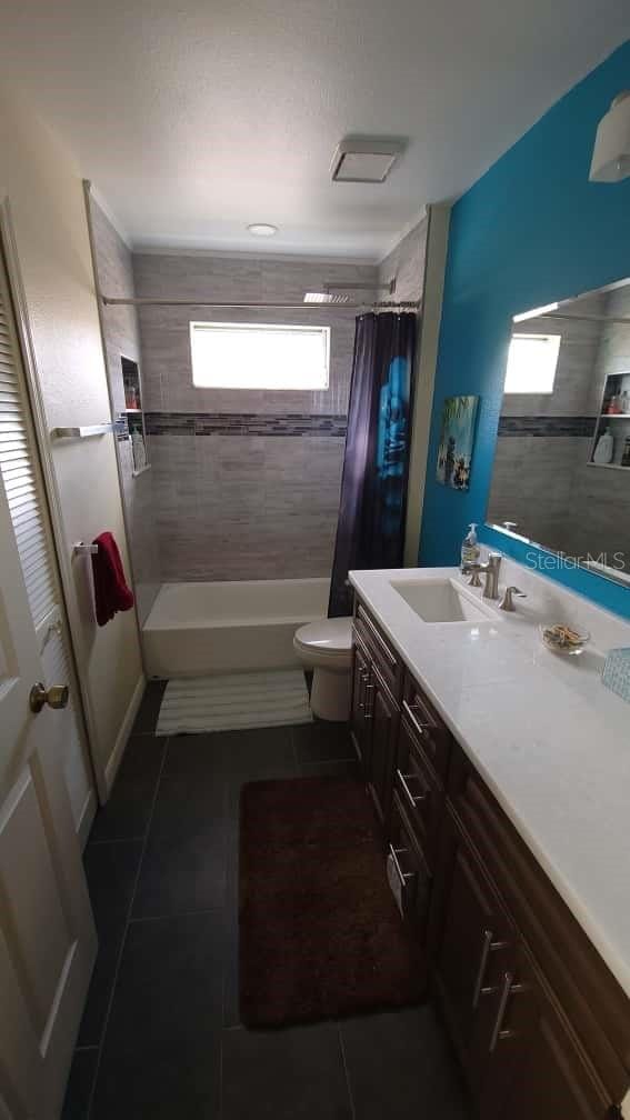 1632 Slash Pine Pl, Oviedo, FL 32765 - bathroom with tile patterned floors, vanity, shower / bath combination with curtain, and plenty of natural light