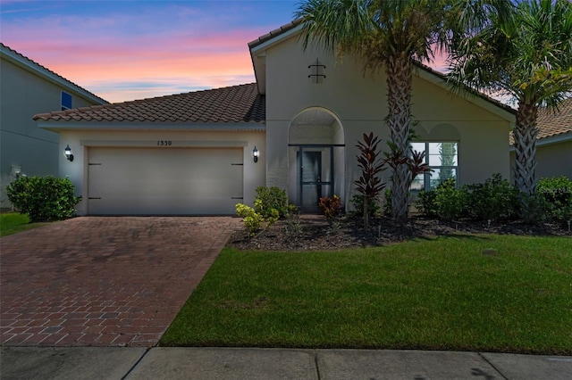 1330 Bucktail Ct, Kissimmee, FL 34746 - mediterranean / spanish-style home with decorative driveway, a tiled roof, a garage, stucco siding, and a front yard