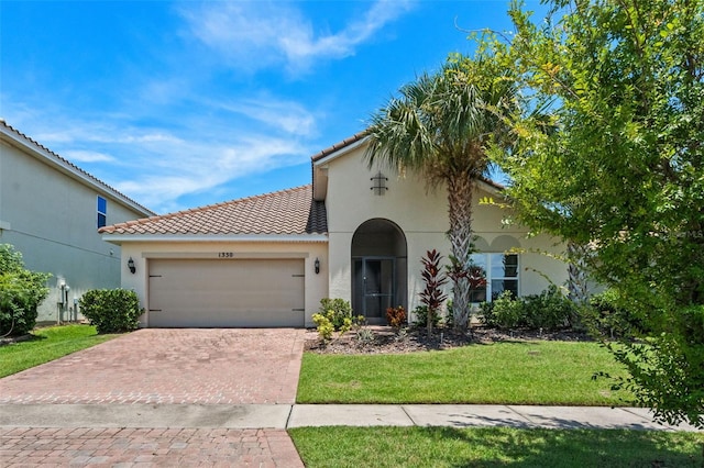 1330 Bucktail Ct, Kissimmee, FL 34746 - mediterranean / spanish home with an attached garage, decorative driveway, a front yard, a tiled roof, and stucco siding