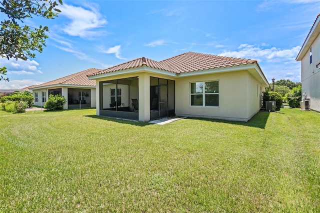 1330 Bucktail Ct, Kissimmee, FL 34746 - rear view of property featuring a tile roof, a sunroom, stucco siding, and a yard