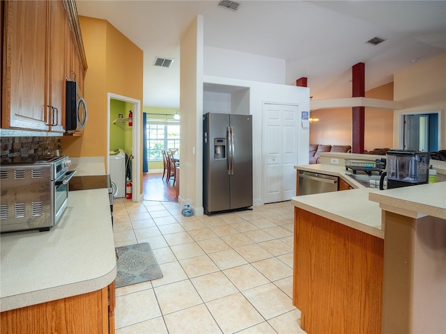 6420 Addax Ave, Cocoa, FL 32927 - kitchen featuring stainless steel appliances, brown cabinets, light countertops, light tile patterned flooring, and open floor plan