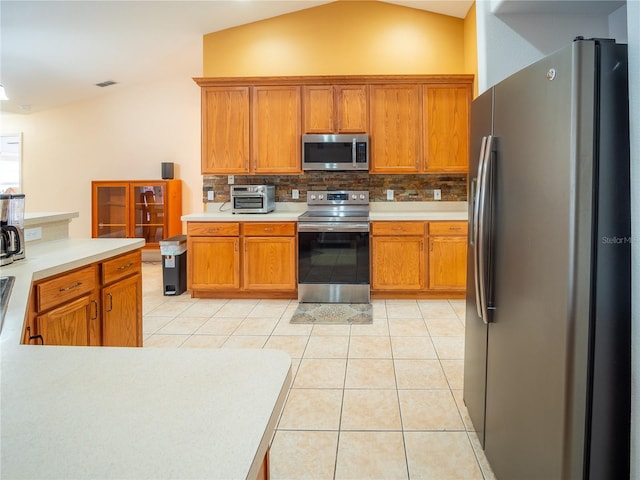 6420 Addax Ave, Cocoa, FL 32927 - kitchen with appliances with stainless steel finishes, tasteful backsplash, light countertops, brown cabinets, and light tile patterned floors