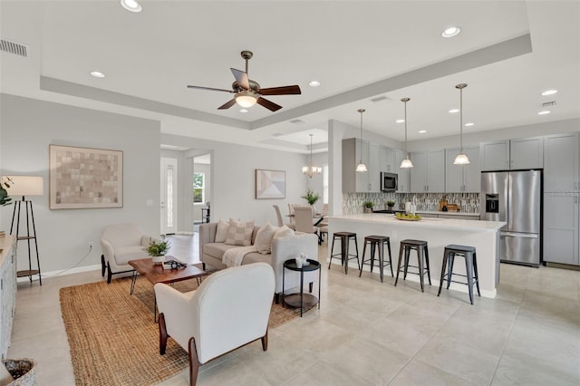 470 Briarbrook Way, Deland, FL 32724 - living room featuring a raised ceiling, ceiling fan, recessed lighting, light tile patterned floors, and a chandelier