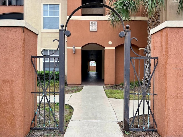 5566 Metrowest Blvd Unit 2-105, Orlando, FL 32811 - view of exterior entry featuring a gate and stucco siding