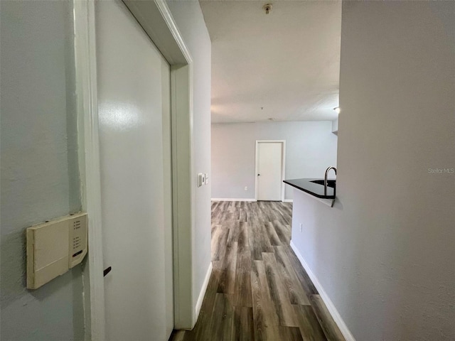 5566 Metrowest Blvd Unit 2-105, Orlando, FL 32811 - hallway featuring wood finished floors and baseboards