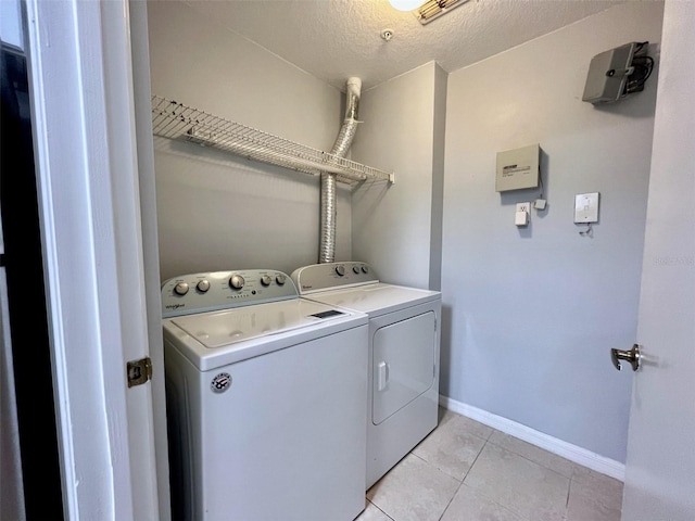5566 Metrowest Blvd Unit 2-105, Orlando, FL 32811 - washroom featuring washing machine and dryer, light tile patterned floors, and a textured ceiling