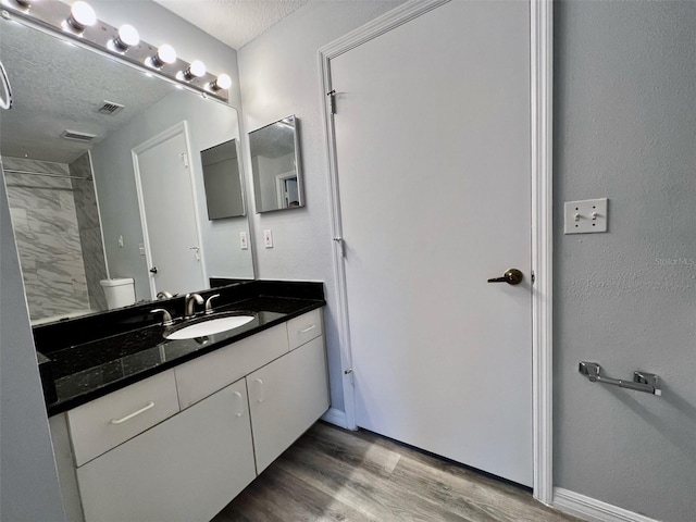 5566 Metrowest Blvd Unit 2-105, Orlando, FL 32811 - full bathroom featuring vanity, wood finished floors, and a textured ceiling