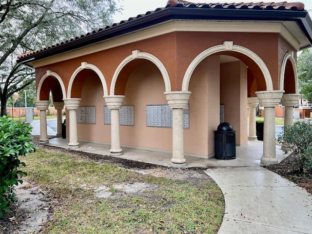 5566 Metrowest Blvd Unit 2-105, Orlando, FL 32811 - view of property exterior featuring mail area, stucco siding, and a tiled roof