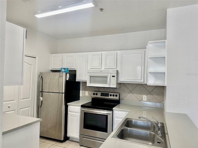 6153 Metrowest Blvd Unit 205, Orlando, FL 32835 - kitchen with stainless steel appliances, white cabinetry, backsplash, and light countertops