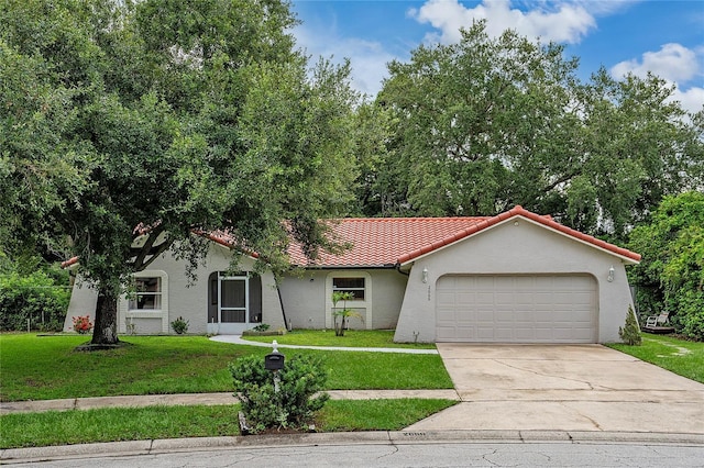 2666 Capp Cir, Kissimmee, FL 34744 - view of front of home featuring a garage, a tile roof, a front yard, and driveway