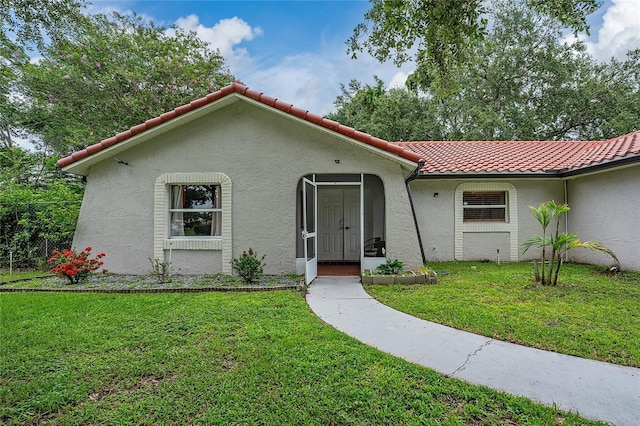 2666 Capp Cir, Kissimmee, FL 34744 - mediterranean / spanish house with a tiled roof, stucco siding, and a front lawn