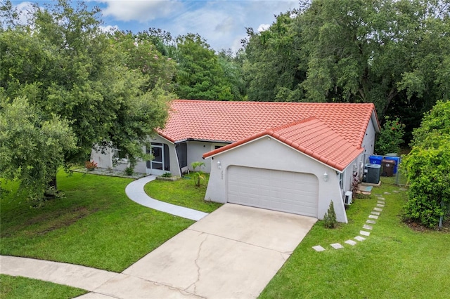 2666 Capp Cir, Kissimmee, FL 34744 - view of front of house featuring a tiled roof, a garage, a front yard, and driveway