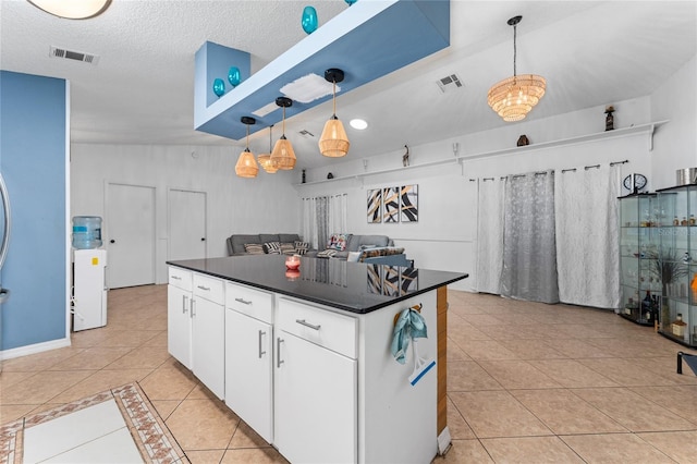 2666 Capp Cir, Kissimmee, FL 34744 - kitchen with light tile patterned flooring, dark countertops, a center island, white cabinets, and pendant lighting