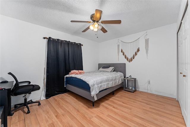 2666 Capp Cir, Kissimmee, FL 34744 - bedroom with light wood-style flooring, a textured ceiling, a closet, an office area, and ceiling fan