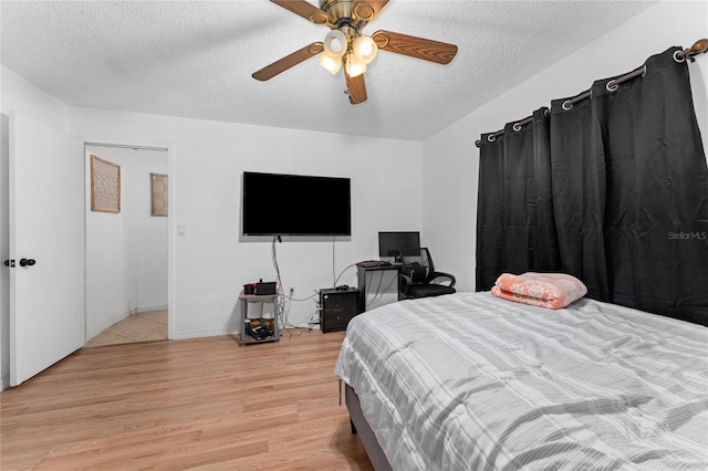 2666 Capp Cir, Kissimmee, FL 34744 - bedroom featuring light wood-type flooring, a textured ceiling, and a ceiling fan