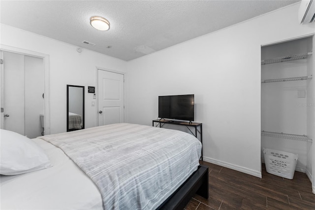 2666 Capp Cir, Kissimmee, FL 34744 - bedroom featuring a wall unit AC, a closet, wood finished floors, and a textured ceiling