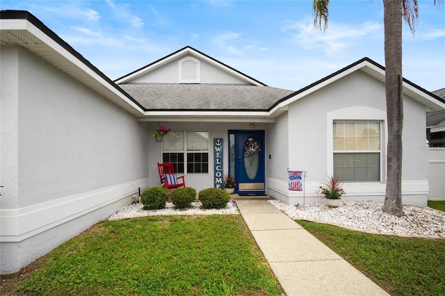 1145 Jaybee Ave, Davenport, FL 33897 - view of front of house featuring roof with shingles, stucco siding, a front yard, and a porch