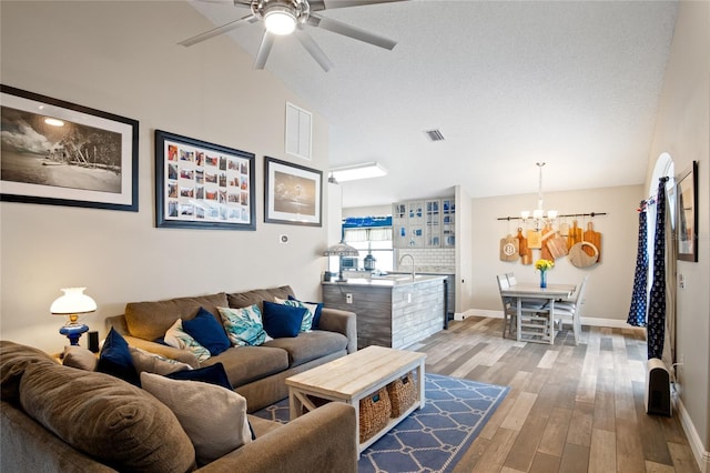 1145 Jaybee Ave, Davenport, FL 33897 - living room featuring a chandelier, ceiling fan, wood finished floors, and high vaulted ceiling