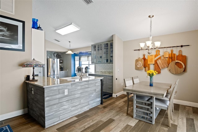 1145 Jaybee Ave, Davenport, FL 33897 - kitchen featuring freestanding refrigerator, a chandelier, dark wood-type flooring, glass insert cabinets, and gray cabinetry