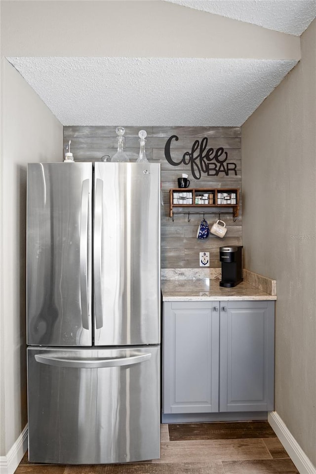 1145 Jaybee Ave, Davenport, FL 33897 - kitchen with freestanding refrigerator, wood finished floors, a textured ceiling, light stone countertops, and open shelves