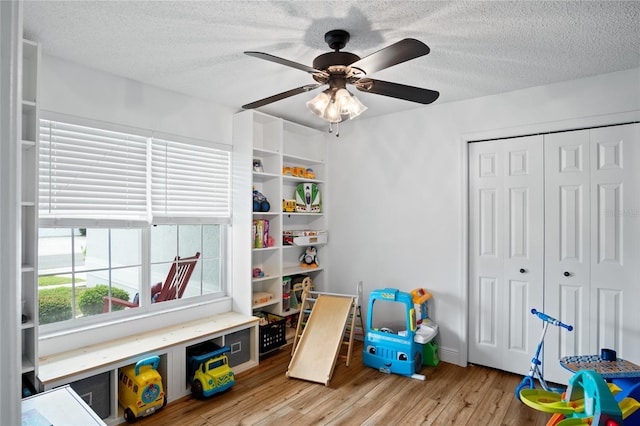 1145 Jaybee Ave, Davenport, FL 33897 - game room featuring light wood-style flooring, a textured ceiling, and ceiling fan