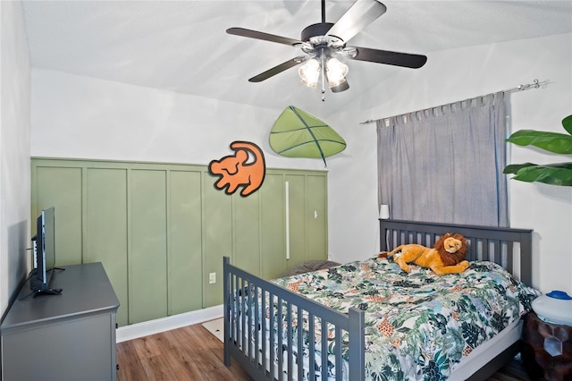 1145 Jaybee Ave, Davenport, FL 33897 - bedroom with vaulted ceiling, a decorative wall, wood finished floors, a ceiling fan, and wainscoting