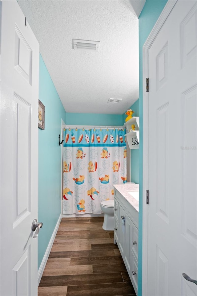 1145 Jaybee Ave, Davenport, FL 33897 - bathroom featuring a textured ceiling, wood finished floors, vanity, and a shower with shower curtain