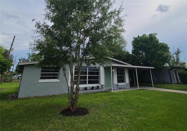 4118 Kirkland Blvd, Orlando, FL 32811 - ranch-style home featuring a front lawn, stucco siding, a carport, and concrete driveway