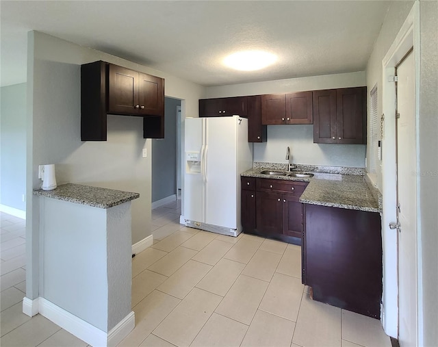 4118 Kirkland Blvd, Orlando, FL 32811 - kitchen featuring white refrigerator with ice dispenser, stone countertops, dark brown cabinetry, and light tile patterned floors