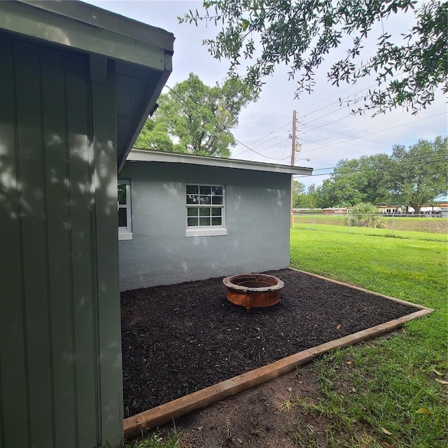 4118 Kirkland Blvd, Orlando, FL 32811 - view of side of property featuring a yard, stucco siding, and an outdoor fire pit
