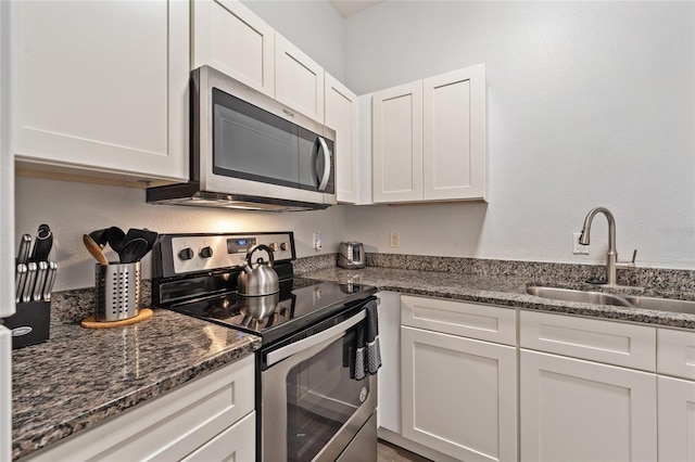 2786 Club Cortile Cir Unit B, Kissimmee, FL 34746 - kitchen featuring stainless steel appliances, white cabinets, and dark stone countertops