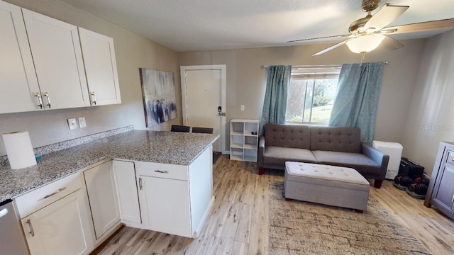 133 Oyster Bay Cir Unit 100, Altamonte Springs, FL 32701 - kitchen with a peninsula, a ceiling fan, light wood finished floors, white cabinetry, and light stone counters