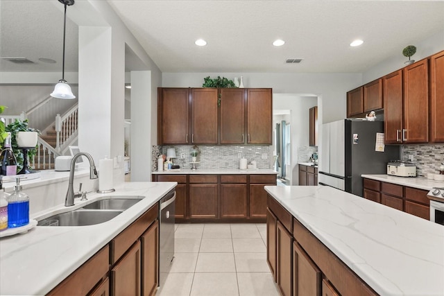 2700 Tree Meadow Loop, Apopka, FL 32712 - kitchen with stainless steel appliances, tasteful backsplash, light tile patterned floors, hanging light fixtures, and light stone counters
