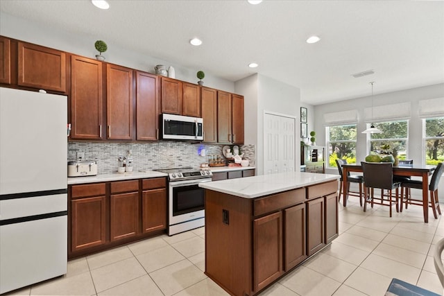 2700 Tree Meadow Loop, Apopka, FL 32712 - kitchen with stainless steel appliances, light countertops, decorative backsplash, decorative light fixtures, and light tile patterned floors
