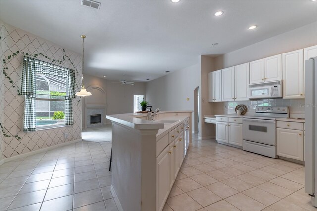 2340 Blackjack Oak St, Ocoee, FL 34761 - kitchen with white appliances, open floor plan, a glass covered fireplace, ceiling fan, and light countertops