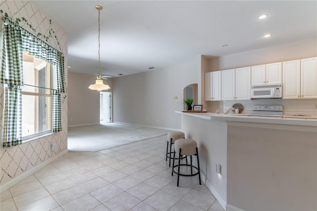 2340 Blackjack Oak St, Ocoee, FL 34761 - kitchen featuring white appliances, arched walkways, light countertops, recessed lighting, and open floor plan