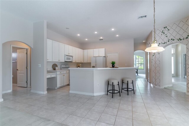 2340 Blackjack Oak St, Ocoee, FL 34761 - kitchen featuring white appliances, arched walkways, light tile patterned floors, and recessed lighting