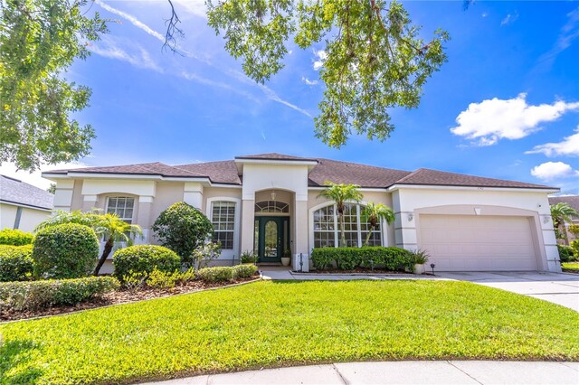 2340 Blackjack Oak St, Ocoee, FL 34761 - mediterranean / spanish-style home featuring a garage, a front yard, concrete driveway, and stucco siding