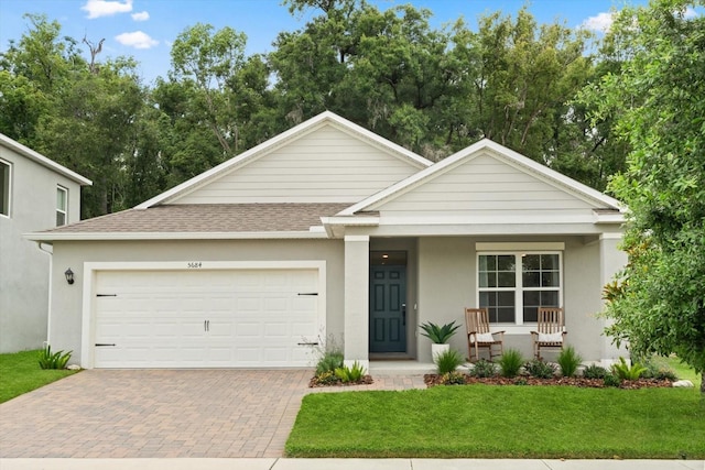 5684 Horseshoe Loop, Apopka, FL 32712 - view of front of property featuring a porch, decorative driveway, a front yard, a garage, and roof with shingles