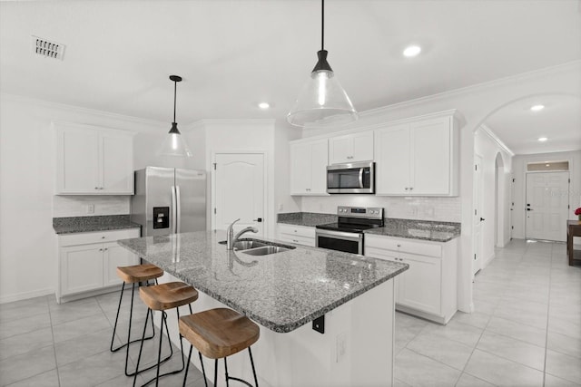 5684 Horseshoe Loop, Apopka, FL 32712 - kitchen featuring appliances with stainless steel finishes, crown molding, a kitchen breakfast bar, light tile patterned flooring, and white cabinets