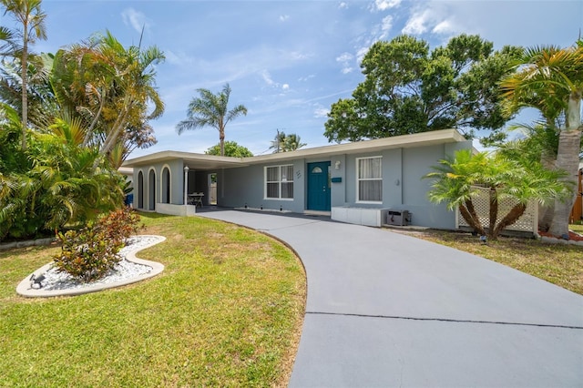 ranch-style home with concrete driveway, a front yard, stucco siding, and a carport